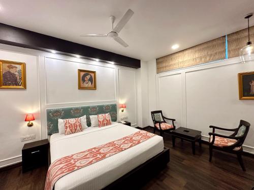a bedroom with a large bed and two chairs at Hotel Atulyaa Taj in Agra