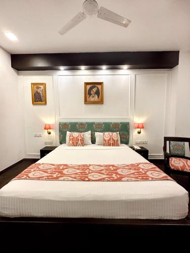 a bedroom with a large bed and two lamps at Hotel Atulyaa Taj in Agra