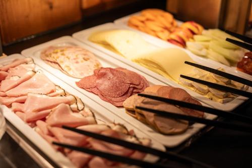 a buffet of different types of food on trays at Hotel & Gasthof Fraundorfer in Garmisch-Partenkirchen