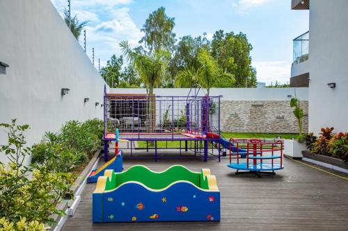 a playground with a table and a trampoline at Villa Palm évasion in Ngaparou