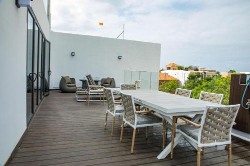 a white table and chairs on a balcony at Villa Palm évasion in Ngaparou