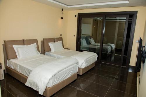two beds in a hotel room with a mirror at Villa Palm évasion in Ngaparou