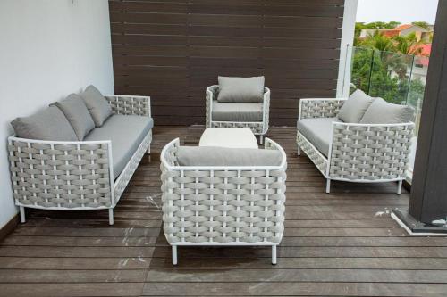a group of wicker chairs and tables on a patio at Villa Palm évasion in Ngaparou