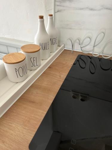 a counter with three white vases on it at La petite maison d'Arbas in Arbas