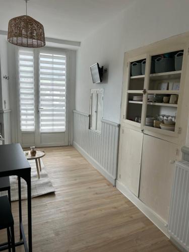 a living room with a large window and a wooden floor at La petite maison d'Arbas in Arbas