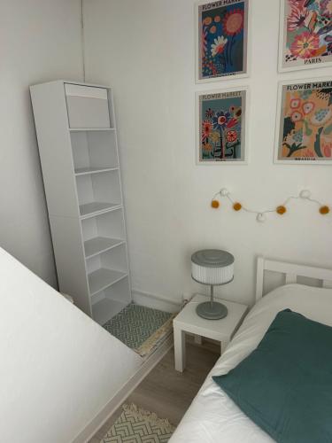 a bedroom with a white book shelf next to a bed at La petite maison d'Arbas in Arbas