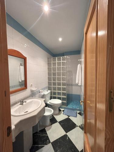 a bathroom with a sink and a toilet and a shower at Hostal el Ancla in Alcalá del Río