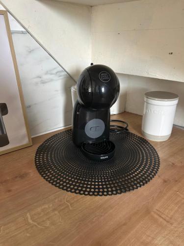 a coffee maker sitting on a mat on the floor at La petite maison d'Arbas in Arbas