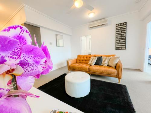 a living room with a couch and a purple flower at Apartments on Connor in Brisbane