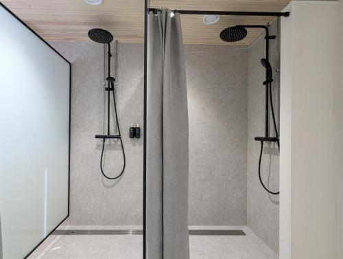 a shower with two shower heads in a bathroom at Arctic Nest in Kotila