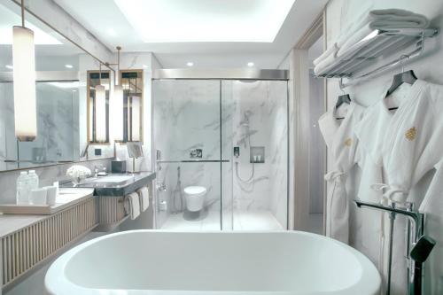 a bathroom with a large tub and a shower at Mason Pine Hotel Bandung in Padalarang
