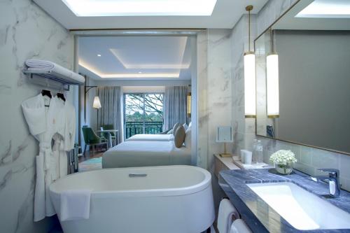 a bathroom with two beds and a toilet and a sink at Mason Pine Hotel Bandung in Padalarang