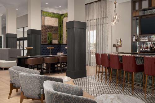 a restaurant with a bar and tables and chairs at Hilton Phoenix Chandler in Chandler