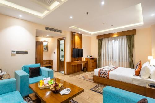 a hotel room with a bed and blue chairs at Dream International Hotel in Lumbini