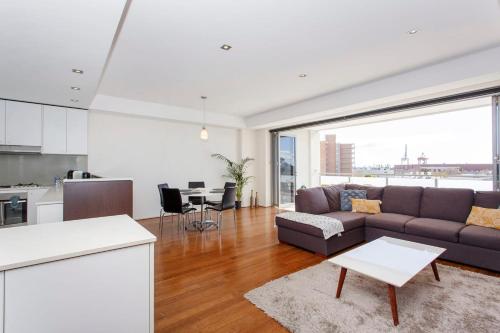 a kitchen and living room with a couch and a table at Freo Family Escape Pool, Port Views & Free Park in Fremantle