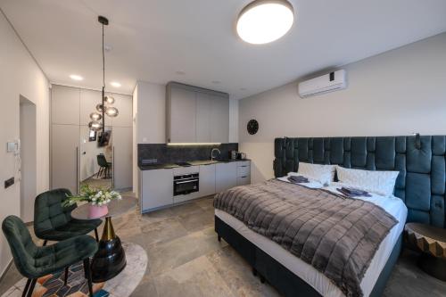a bedroom with a large bed and a kitchen at Old Town - Bajor Studios 2 - Self Check-in and Parking in Kaunas