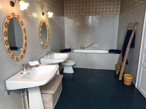 une salle de bain avec deux lavabos et une baignoire et des toilettes dans l'établissement Chez Célia Bed&Breakfast, à Champdeniers