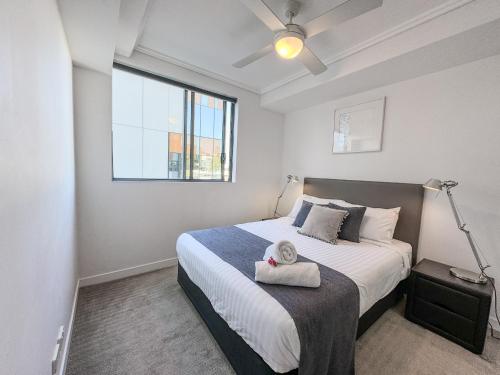 a bedroom with a bed with a towel on it at Apartments on Connor in Brisbane