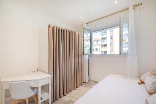 a bedroom with a bed and a desk and a window at WILSON Juan les pins 6 couchages 100m des plages in Antibes
