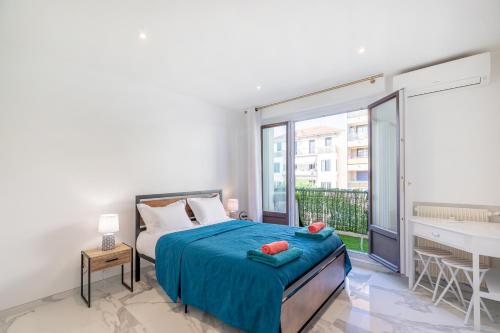 a bedroom with a bed and a balcony with a desk at WILSON Juan les pins 6 couchages 100m des plages in Antibes
