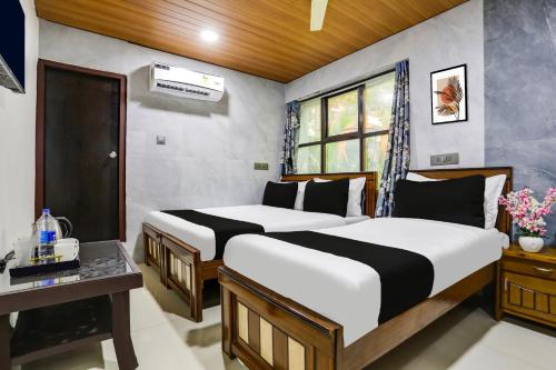 a bedroom with two beds and a desk and a window at Super Hotel O Madhapur VIP Hills in Hyderabad
