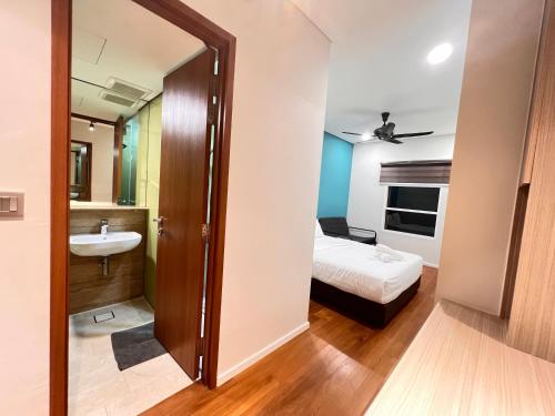 a bathroom with a sink and a bed in a room at Sky Suites at KLCC by Mitstay in Kuala Lumpur