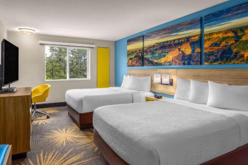 a hotel room with two beds and a flat screen tv at Days Inn by Wyndham Williams in Williams