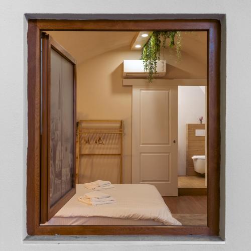a mirror reflecting a bedroom with a bed and a bathroom at Epic Boutique in Sibiu
