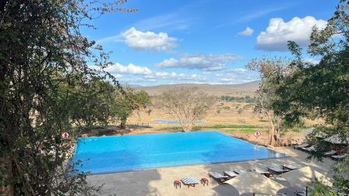 a swimming pool with a view of a field at Taita Hills Safari Resort & Spa in Tsavo