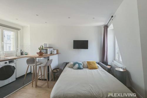une petite chambre avec un lit et une cuisine dans l'établissement Flexliving - studio - Legendre, à Paris
