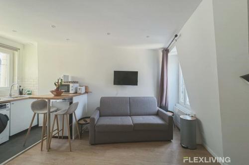 un salon avec un canapé et une table dans l'établissement Flexliving - studio - Legendre, à Paris
