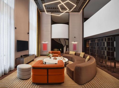 a living room with a couch and a table and chairs at Conrad Urumqi in Ürümqi