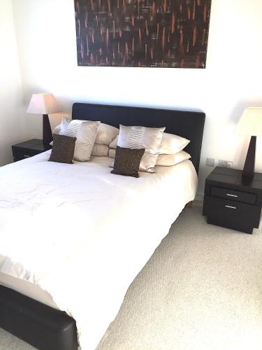 a bedroom with a bed with white sheets and pillows at Penthouse - 2 Bed - 2 Bath - Free Parking in Bedford