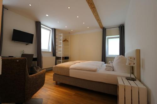 a bedroom with a bed and a tv and a chair at Altes Forsthaus Braunlage in Braunlage
