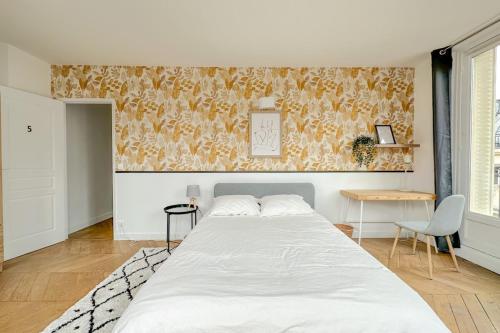 - une chambre avec un grand lit blanc et un mur dans l'établissement Flexliving - room - Septembre, à Paris