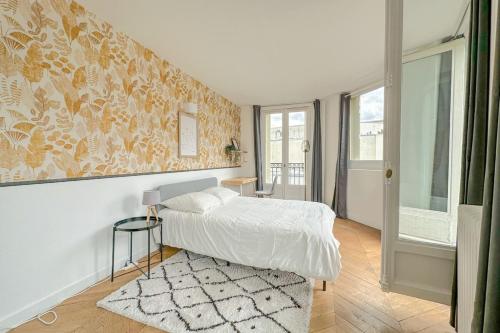 - une chambre blanche avec un lit et un tapis dans l'établissement Flexliving - room - Septembre, à Paris