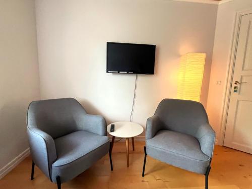 two chairs and a table in a room with a tv at Johnnys Bed & Breakfast in Nykøbing Falster