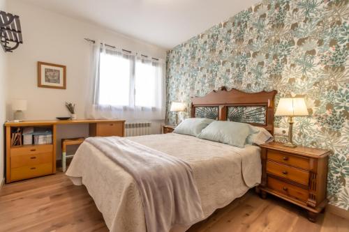 une chambre avec un lit et un mur avec du papier peint à fleurs dans l'établissement Apartamento San Fabian de Bossost, à Bossost