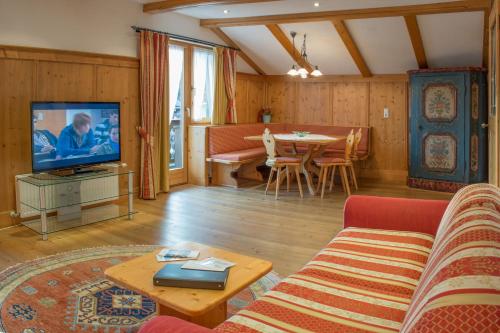 a living room with a couch and a tv and a table at Gästehaus "Ski-Depot" in Seefeld in Tirol