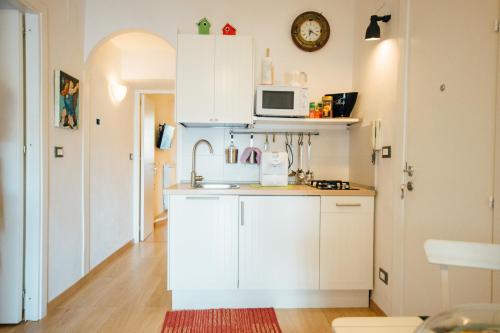 a kitchen with white cabinets and a microwave at Bed à Cala in Palermo