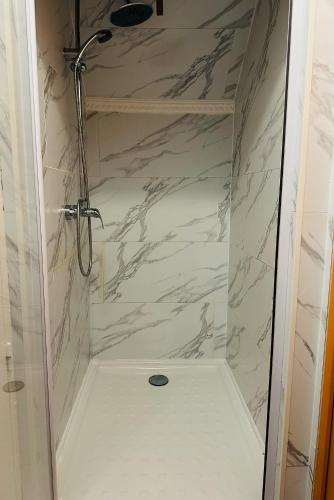 une douche avec une porte vitrée dans une salle de bain dans l'établissement Espace Piscine et SPA Villa des Cortins, à Dierrey-Saint-Julien