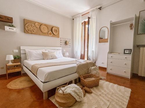 ein Schlafzimmer mit einem weißen Bett und einem Spiegel in der Unterkunft Amy B&B casetta di charme in Vercelli