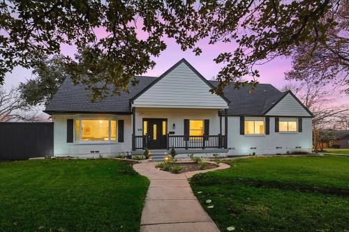 a white house with lights on in a yard at Upscale 6BR 2,5BA Holiday Home with Pool, Hot Tub & Game Room in Farmers Branch