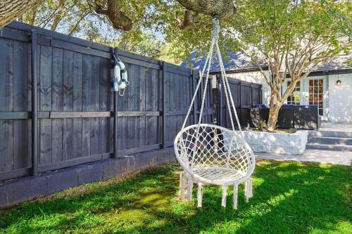 a swinging chair in a yard next to a fence at Upscale 6BR 2,5BA Holiday Home with Pool, Hot Tub & Game Room in Farmers Branch
