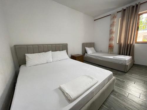 Un dormitorio con dos camas y una ventana. en Thethi Mountain, en Theth
