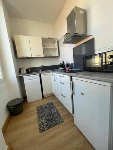 une cuisine avec des appareils blancs et un parquet dans l'établissement Le Pardigon -Fibre-Climatisation, à Marseille