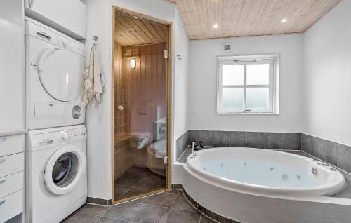 a bathroom with a tub and a washing machine at Lovely Home In Fur With Sauna in Fur