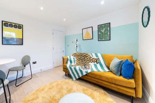 a living room with a yellow couch and a table at Stay Kula London - Covent Garden Opera House in London
