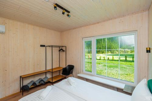 a bedroom with a bed and a window at Namelis ant ežero kranto "Giliaus Elingas" in Tytuvėnai