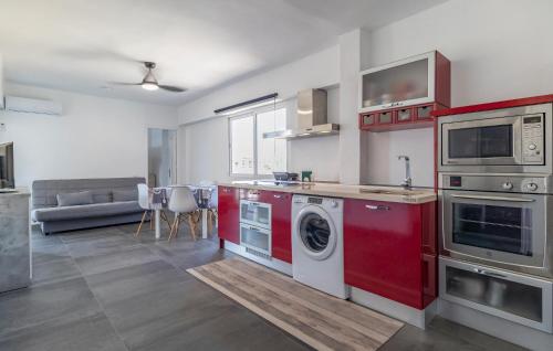 cocina con armarios rojos y lavadora en Beautiful Apartment In Aguadulce, en Aguadulce